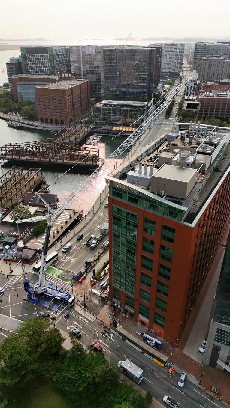 CJ Shaughnessy crane working the 470 Atlantic Avenue site, boom extended over the building beside Fort Point Channel