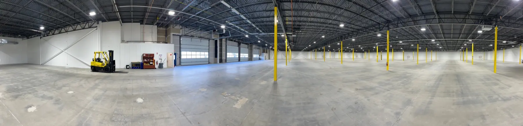 Interior of a large, clean CJ Shaughnessy warehouse with a forklift